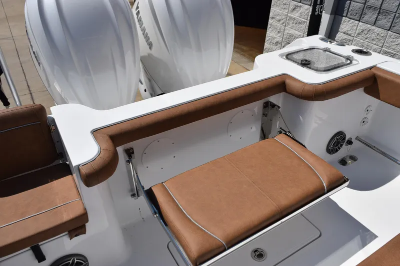 Slide: The Image of 2026 Sea Hunt Gamefish 27 boat interior with brown seating and dual Yamaha engines. - 13