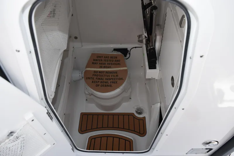 Slide: The Image of 2026 Sea Hunt Gamefish 27 Forward Seating boat interior with toilet and protective film. - 19