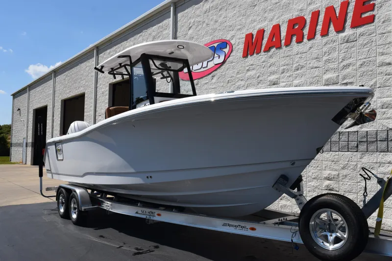Slide: The Image of 2026 Sea Hunt Gamefish 27 boat on trailer outside marine dealership. - 2