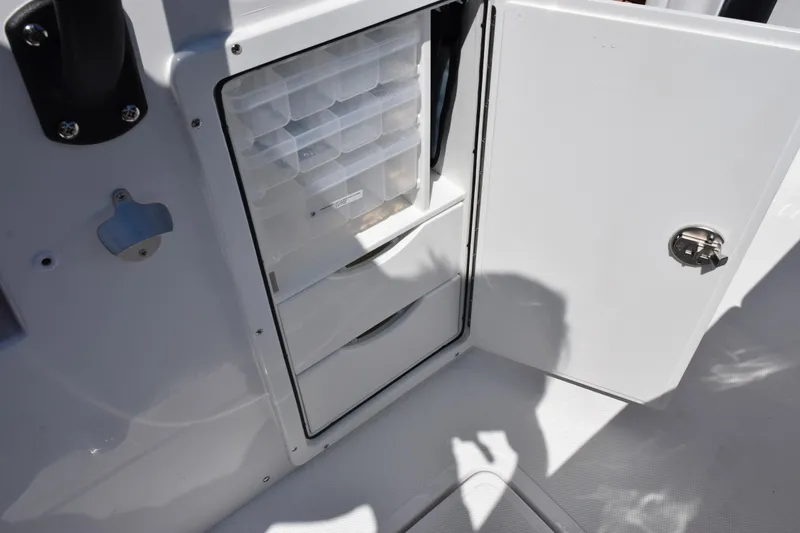 Slide: The Image of Open storage compartment on 2026 Sea Hunt Gamefish 27 boat, featuring organized tackle boxes. - 24