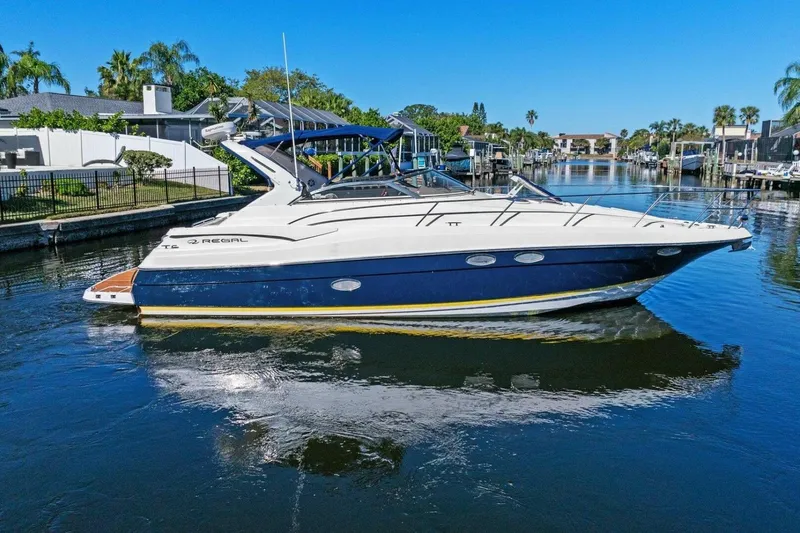 The Image of 2005 Regal Commodore 3560 yacht on a sunny canal, surrounded by waterfront homes. - 1