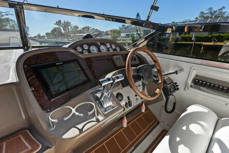 Slide: The Image of 2005 Regal Commodore 3560 boat cockpit with steering wheel and navigation controls. - 13