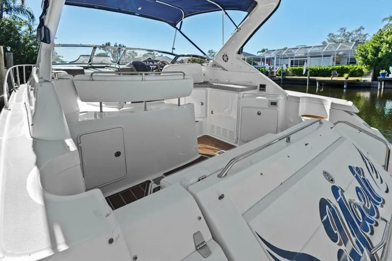 Slide: The Image of 2005 Regal Commodore 3560 yacht interior with seating and helm, docked by waterfront homes. - 19