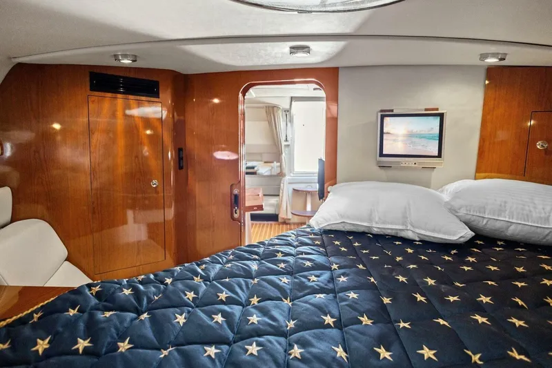 Slide: The Image of Luxurious 2005 Regal Commodore 3560 yacht cabin with star-patterned bedding and TV. - 28