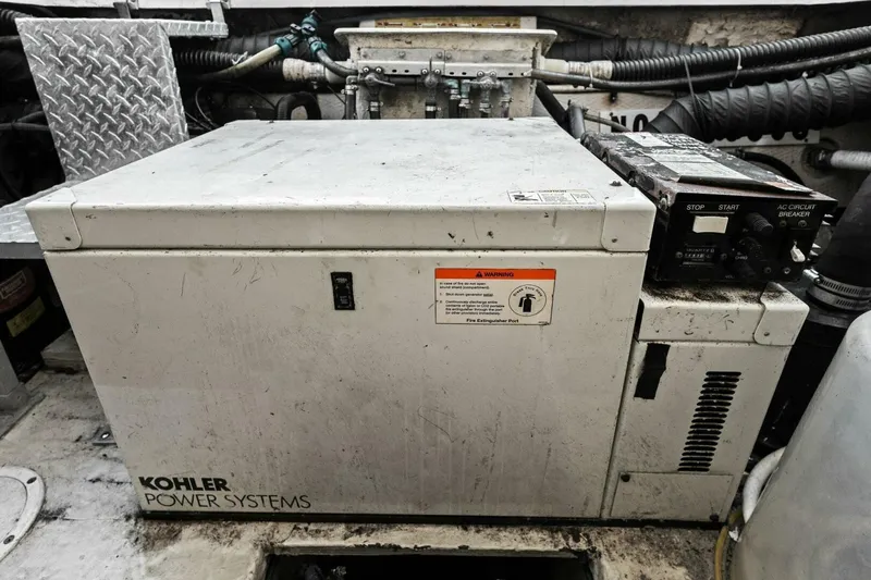 Slide: The Image of Kohler power system in 2005 Regal Commodore 3560 engine room, showing control panel and warning label. - 38