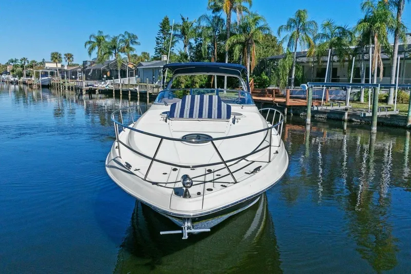 Slide: The Image of 2005 Regal Commodore 3560 yacht docked in a scenic waterfront setting with palm trees. - 4