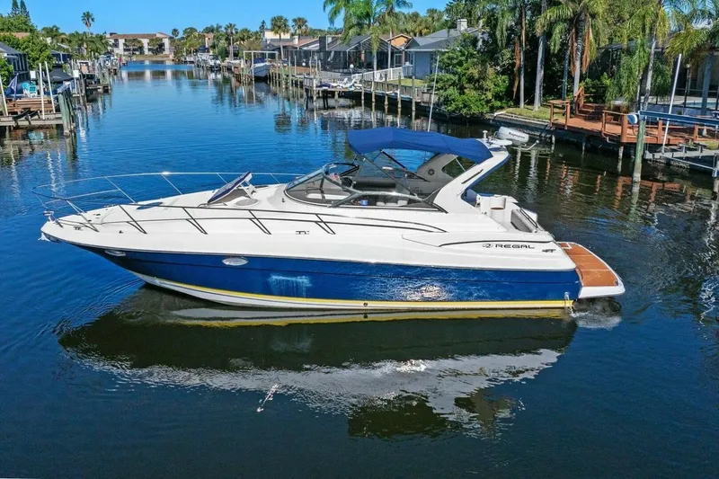 Slide: The Image of 2005 Regal Commodore 3560 yacht cruising in a scenic canal with palm trees. - 6