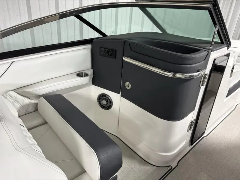 Slide: The Image of 2026 Regal LX4 boat interior with white and black seating, cup holder, and speaker. - 15