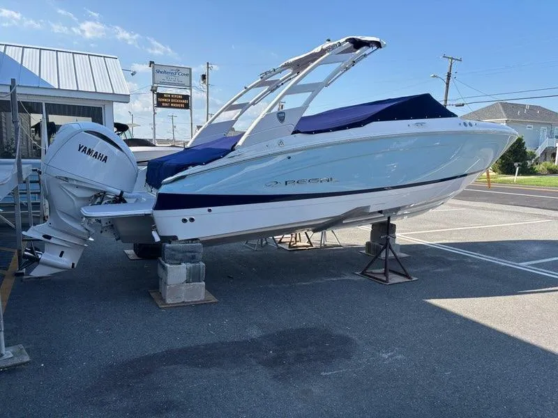 Slide: The Image of 2026 Regal LX4 boat with Yamaha engine on display in a parking lot. - 2