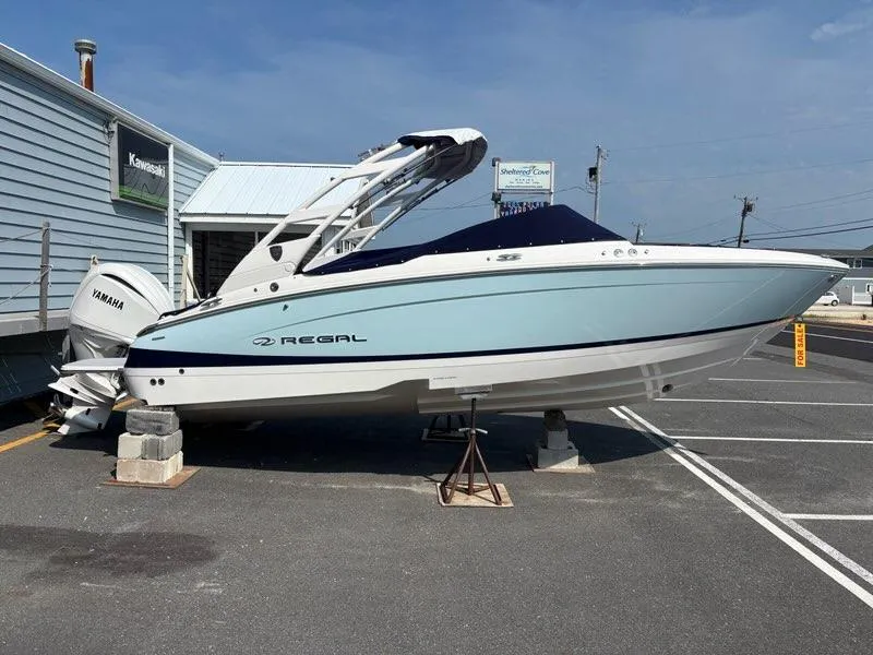 Slide: The Image of 2026 Regal LX4 boat on display with Yamaha engine, parked on stands. - 5