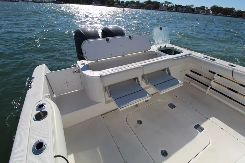 Slide: The Image of 2009 Everglades 320 Center Console boat interior with seating and storage, on water. - 15