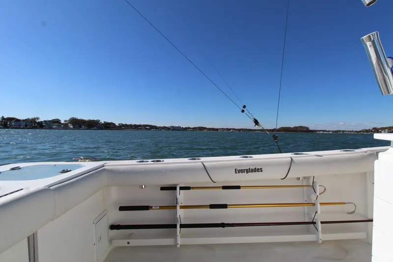 Slide: The Image of 2009 Everglades 320 Center Console boat on water, clear sky, fishing rods visible. - 16