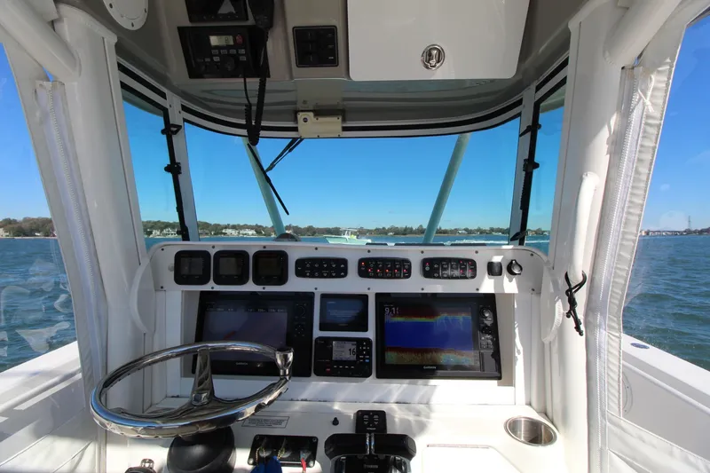 Slide: The Image of 2009 Everglades 320 Center Console boat dashboard with navigation equipment and steering wheel. - 17