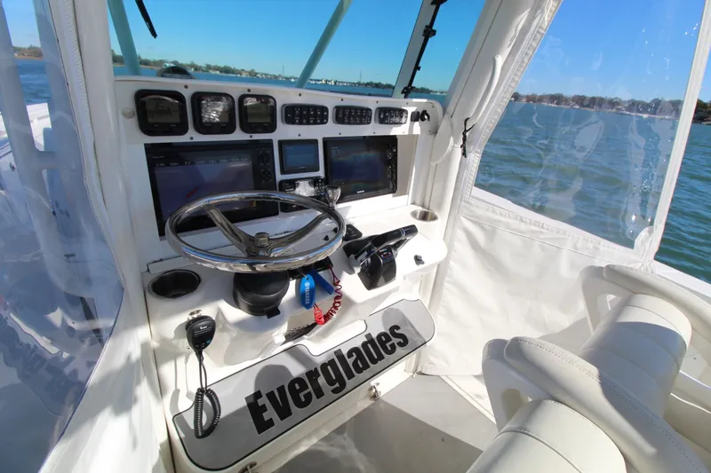 Slide: The Image of 2009 Everglades 320 Center Console boat cockpit with steering wheel and navigation instruments. - 19