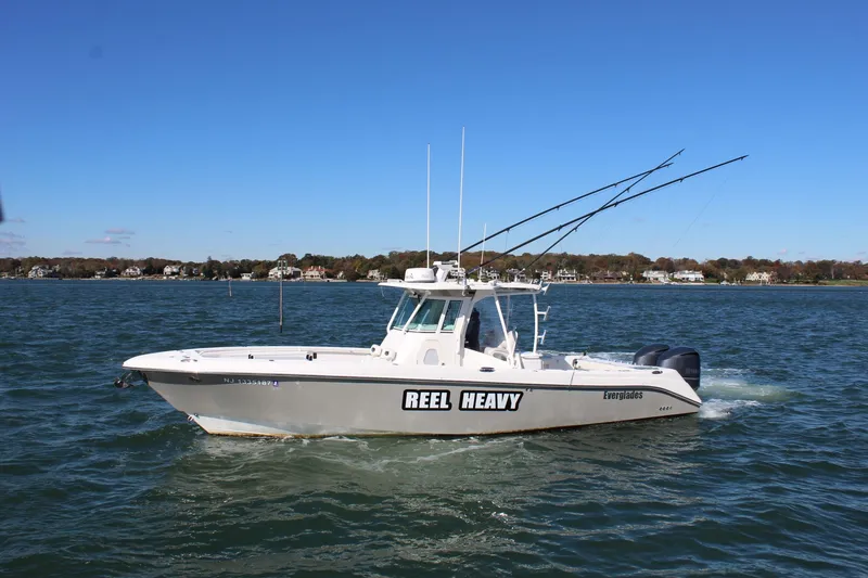Slide: The Image of 2009 Everglades 320 Center Console boat named "Reel Heavy" on water. - 2