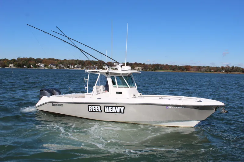 Slide: The Image of 2009 Everglades 320 Center Console boat on water, clear sky, distant shoreline. - 3