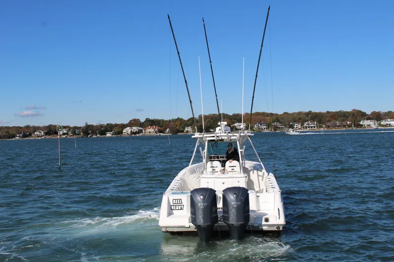 Slide: The Image of 2009 Everglades 320 Center Console boat on water, dual engines, fishing rods, scenic background. - 5