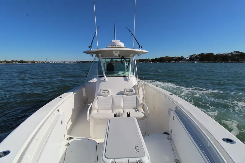 Slide: The Image of 2009 Everglades 320 Center Console boat cruising on open water under clear blue sky. - 8