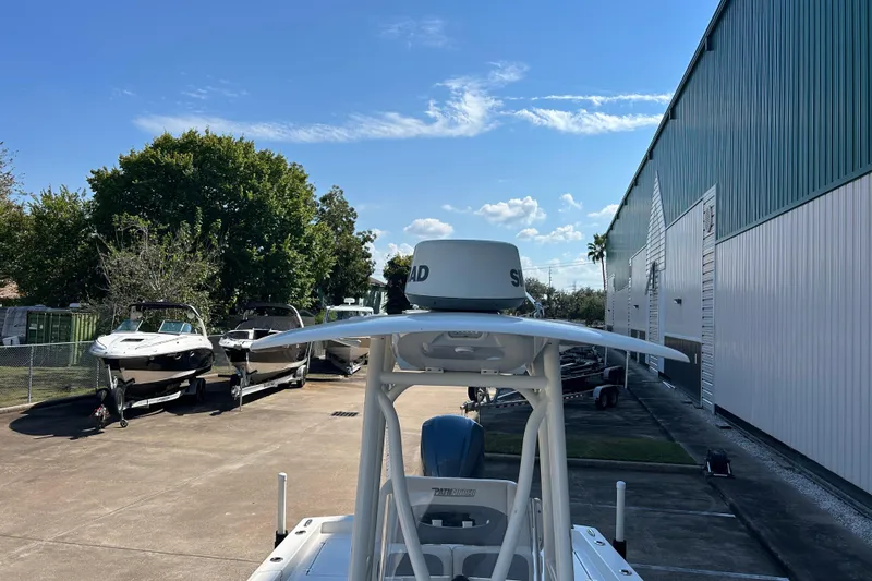 Slide: The Image of 2019 Pathfinder 2600 HPS boat parked outdoors near other boats and a large building. - 36