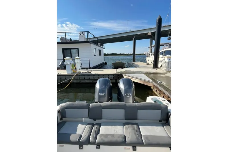 Slide: The Image of 2023 NauticStar 2602 Legacy boat docked, featuring dual 150 horsepower engines. - 4