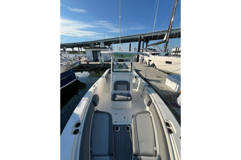 Slide: The Image of 2023 NauticStar 2602 Legacy boat docked at marina under clear blue sky. - 5