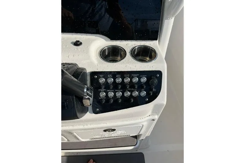 Slide: The Image of 2023 NauticStar 2602 Legacy boat console with controls and cup holders. - 7