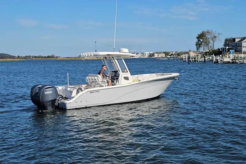 The Image of 2024 Sea Fox 268 Commander boat cruising on a calm lake with scenic background. - 0