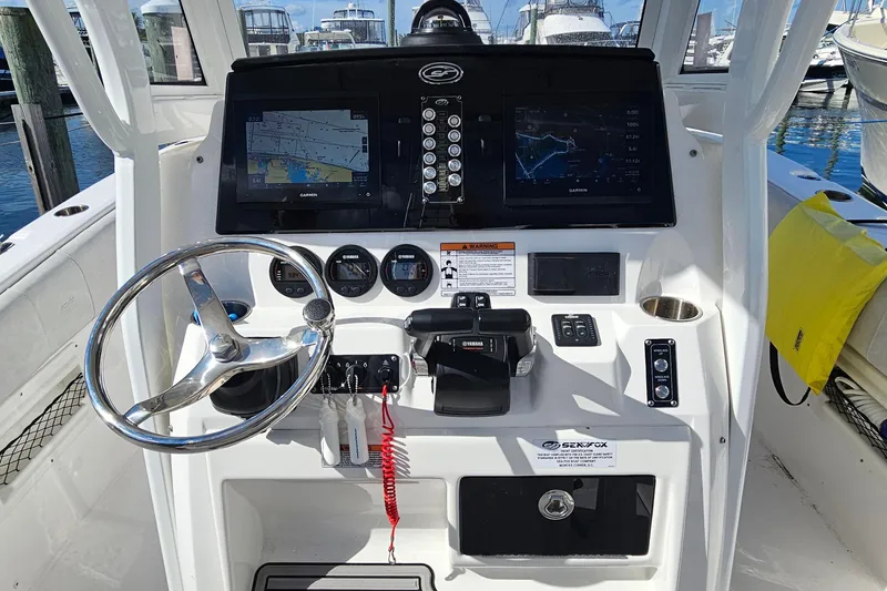Slide: The Image of 2024 Sea Fox 268 Commander boat dashboard with steering wheel and navigation screens. - 15