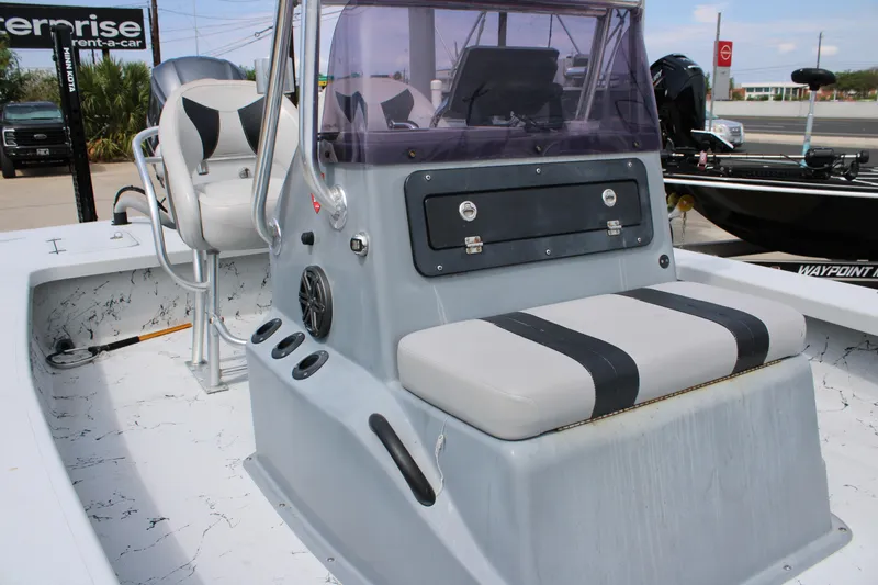 Slide: The Image of 2014 Majek Xtreme 25 boat interior with seating and console, parked outdoors. - 18