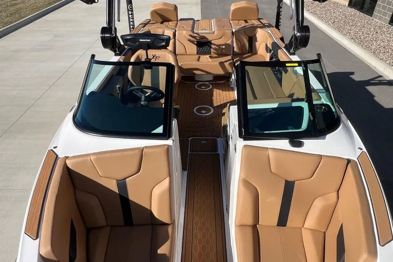 Slide: The Image of 2025 MasterCraft XT23 boat interior with tan leather seats and sleek design. - 10