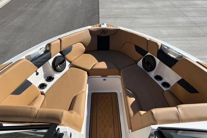 Slide: The Image of 2025 MasterCraft XT23 boat interior with tan seating and built-in speakers. - 11
