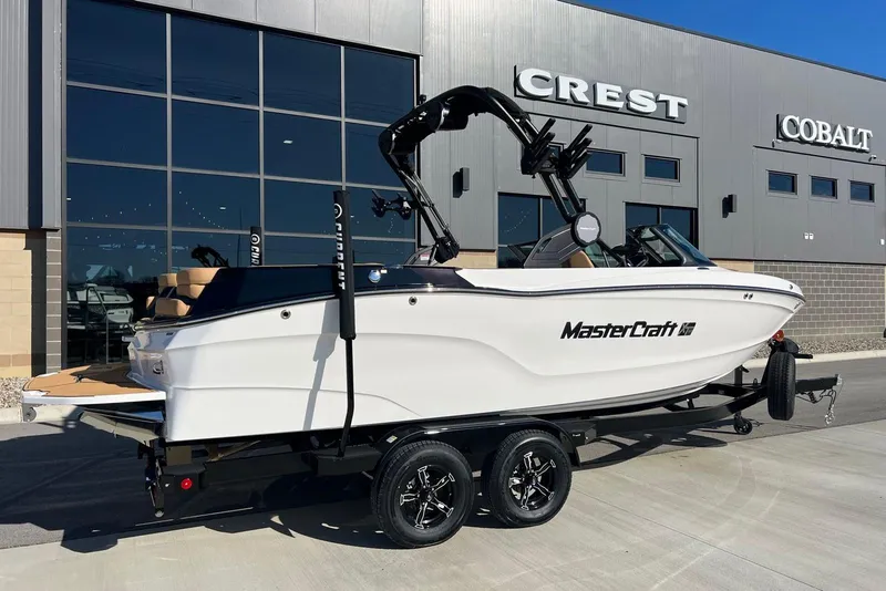 Slide: The Image of 2025 MasterCraft XT23 boat on trailer outside dealership. - 3