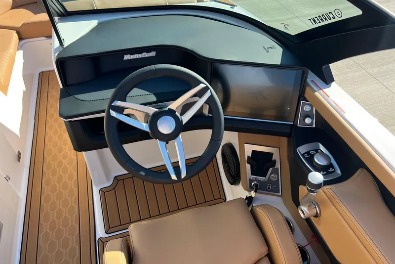 Slide: The Image of 2025 MasterCraft XT23 boat dashboard with modern steering and touchscreen controls. - 8