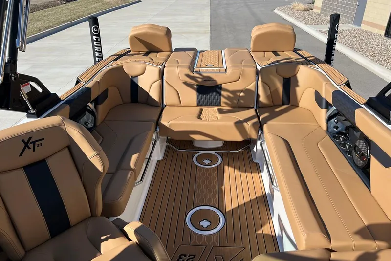 Slide: The Image of 2025 MasterCraft XT23 boat interior with tan leather seating and teak flooring. - 9