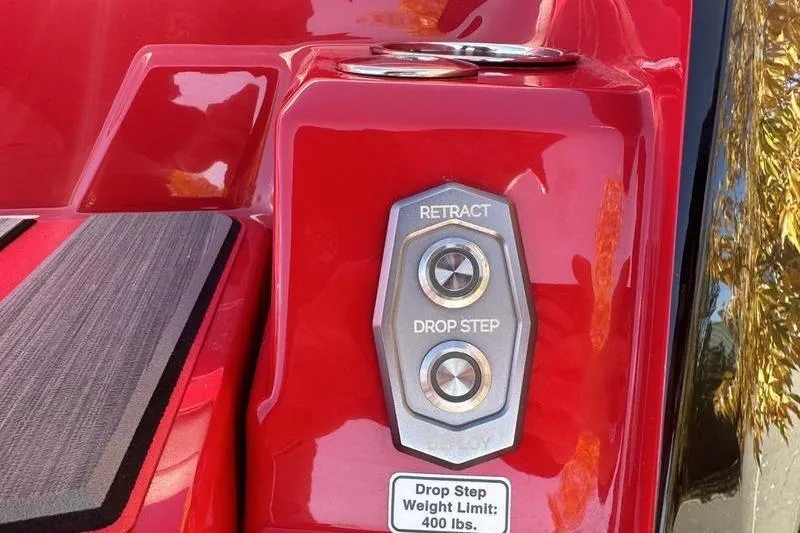 Slide: The Image of 2024 Supra SE 575 drop step controls on red exterior with weight limit label. - 11
