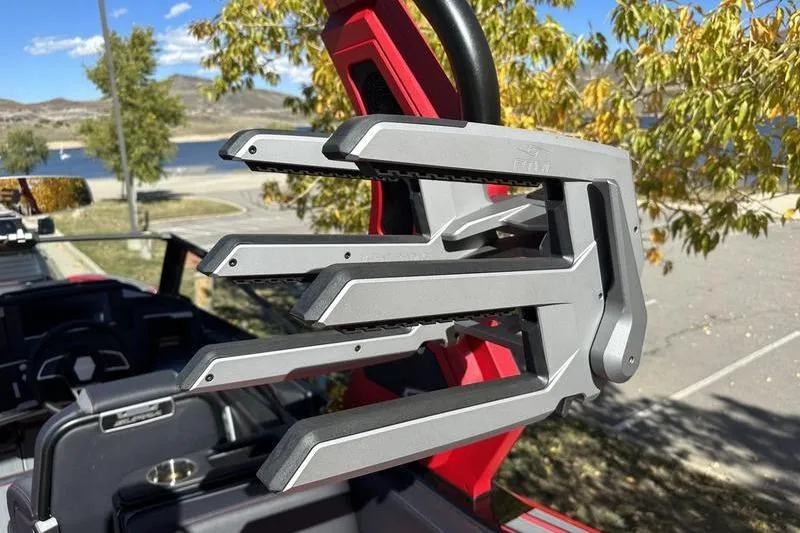 Slide: The Image of 2024 Supra SE 575 boat with a sleek wakeboard rack, set against a scenic lakeside backdrop. - 6