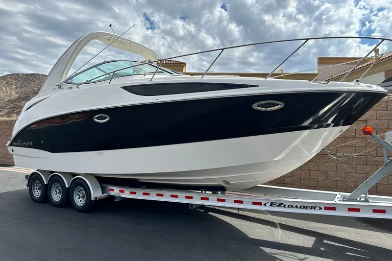 Slide: The Image of 2012 Bayliner 285 Cruiser interior with white seating and helm, showcasing spacious design. - 11
