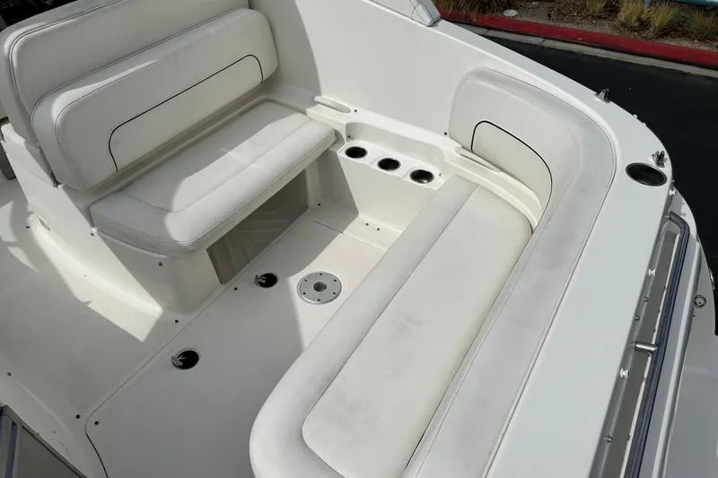Slide: The Image of 2012 Bayliner 285 Cruiser interior seating with white upholstery and cup holders. - 14