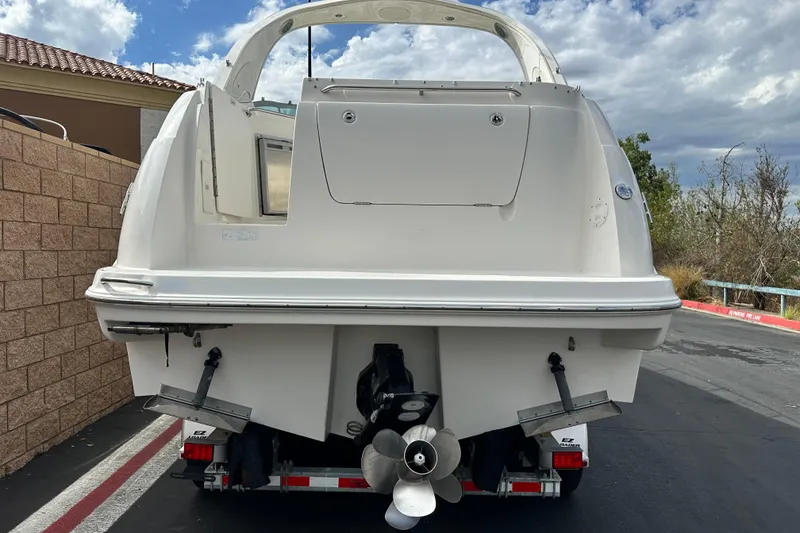 Slide: The Image of 2012 Bayliner 285 Cruiser on trailer, parked outdoors under cloudy sky. - 5