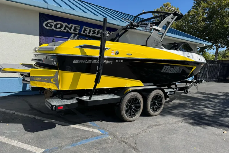 Slide: The Image of 2017 Malibu Wakesetter 23 LSV boat in vibrant yellow and black, parked on a trailer. - 1
