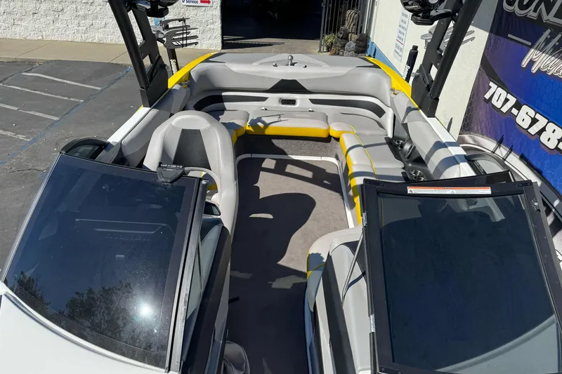 Slide: The Image of 2017 Malibu Wakesetter 23 LSV interior with gray and yellow seating, parked outdoors. - 16