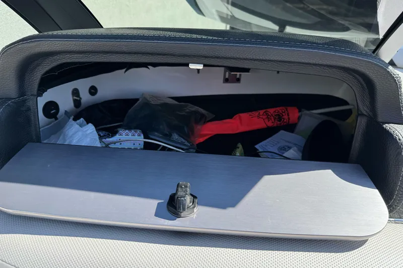 Slide: The Image of Storage compartment in a 2017 Malibu Wakesetter 23 LSV boat, containing various items. - 23