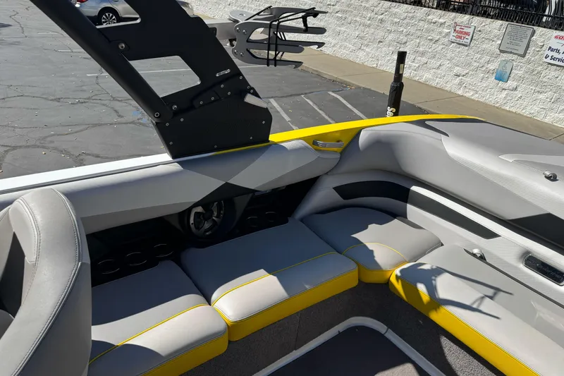 Slide: The Image of 2017 Malibu Wakesetter 23 LSV interior with gray and yellow seating, docked outdoors. - 26