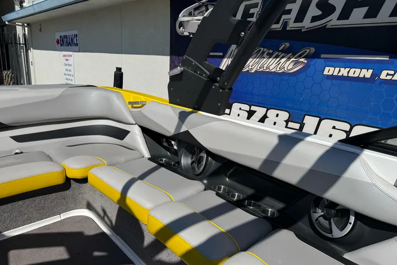 Slide: The Image of 2017 Malibu Wakesetter 23 LSV interior with gray and yellow seating, cup holders, and speakers. - 28