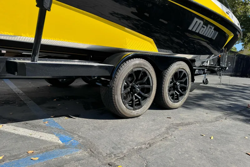 Slide: The Image of 2017 Malibu Wakesetter 23 LSV on trailer, black wheels, yellow and black design. - 5