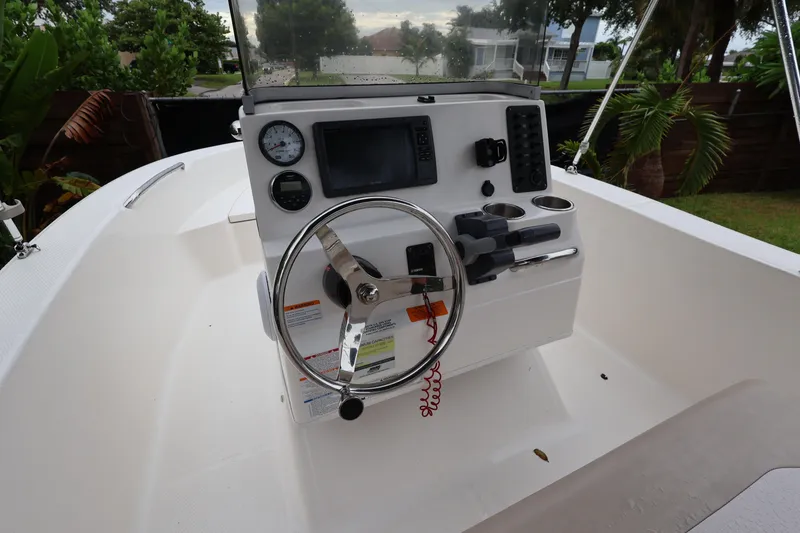 Slide: The Image of 2016 Robalo R160 Center Console boat dashboard with steering wheel and controls. - 10