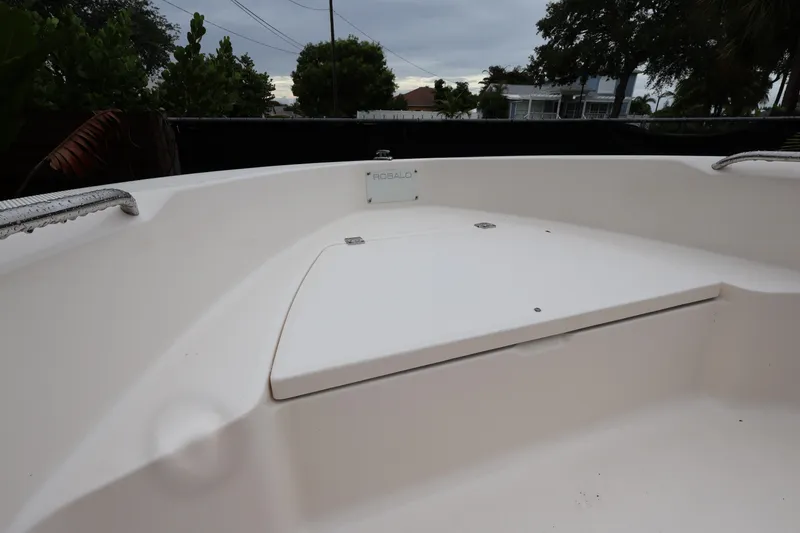 Slide: The Image of 2016 Robalo R160 Center Console boat deck, featuring storage compartment and sleek design. - 11