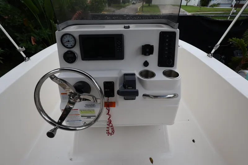 Slide: The Image of 2016 Robalo R160 Center Console boat dashboard with steering wheel and controls. - 17
