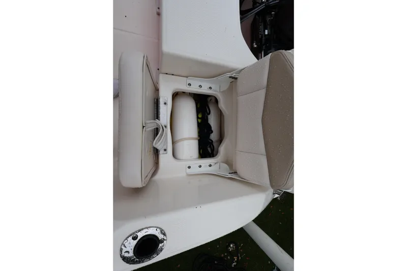 Slide: The Image of 2016 Robalo R160 Center Console boat seat storage compartment with visible equipment. - 26