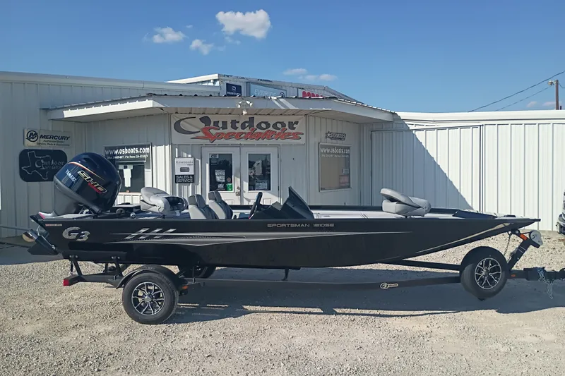The Image of 2026 G3 1810SE boat on trailer outside dealership under clear blue sky. - 1